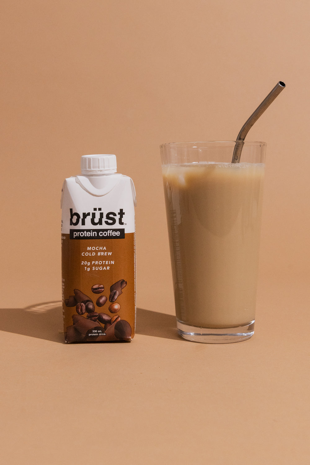brüst mocha protein cold brew coffee bottle beside a glass of iced coffee